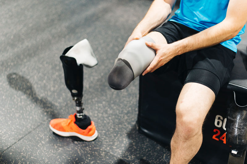 disabled athlete assembling his leg prosthesis
