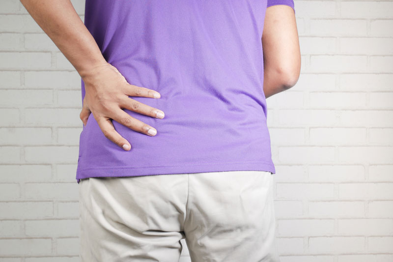 young man suffering back pain close